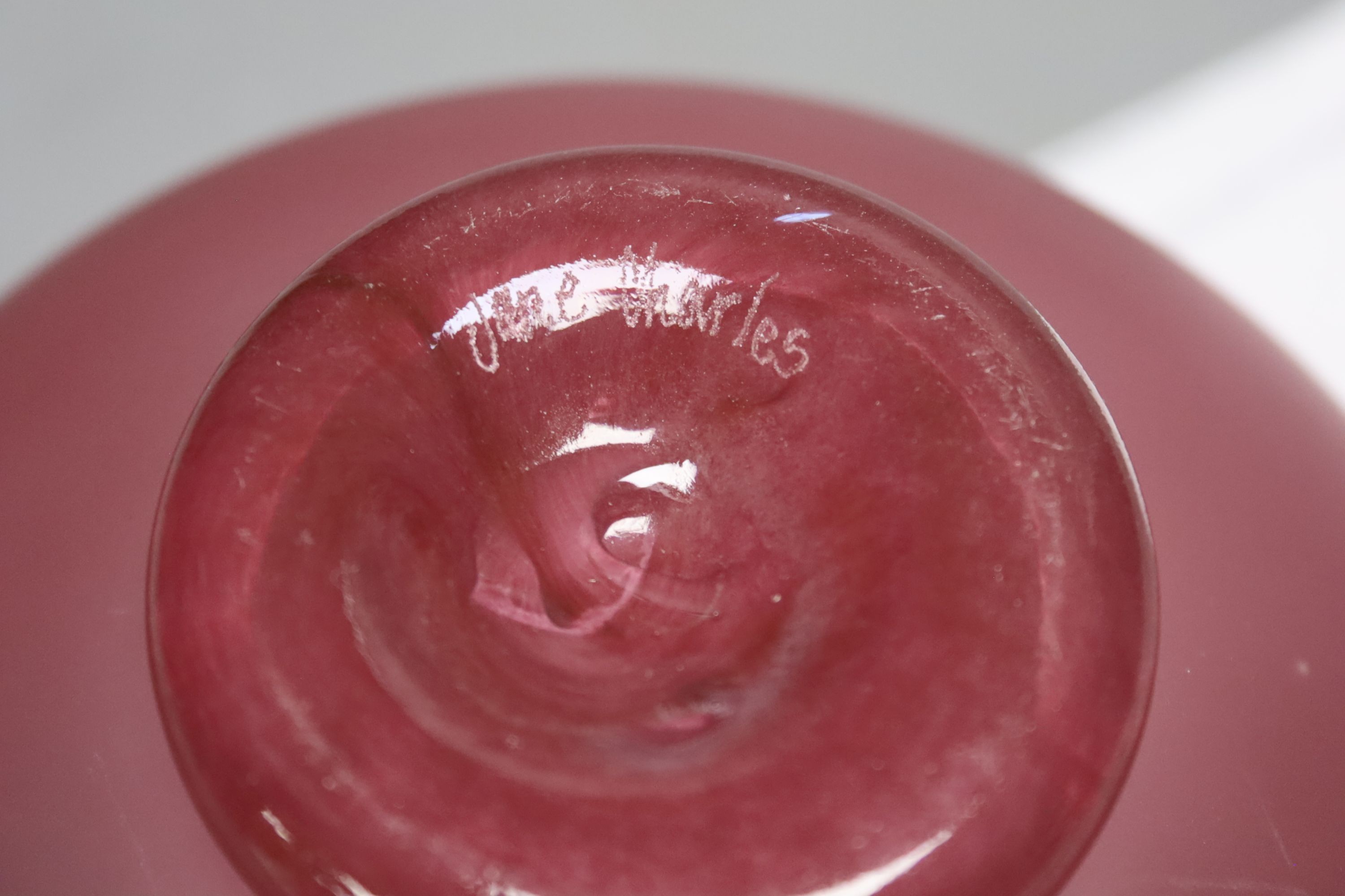 Two Jane Charles art glass disc panels and a pink art glass bowl, tallest 15.5cm